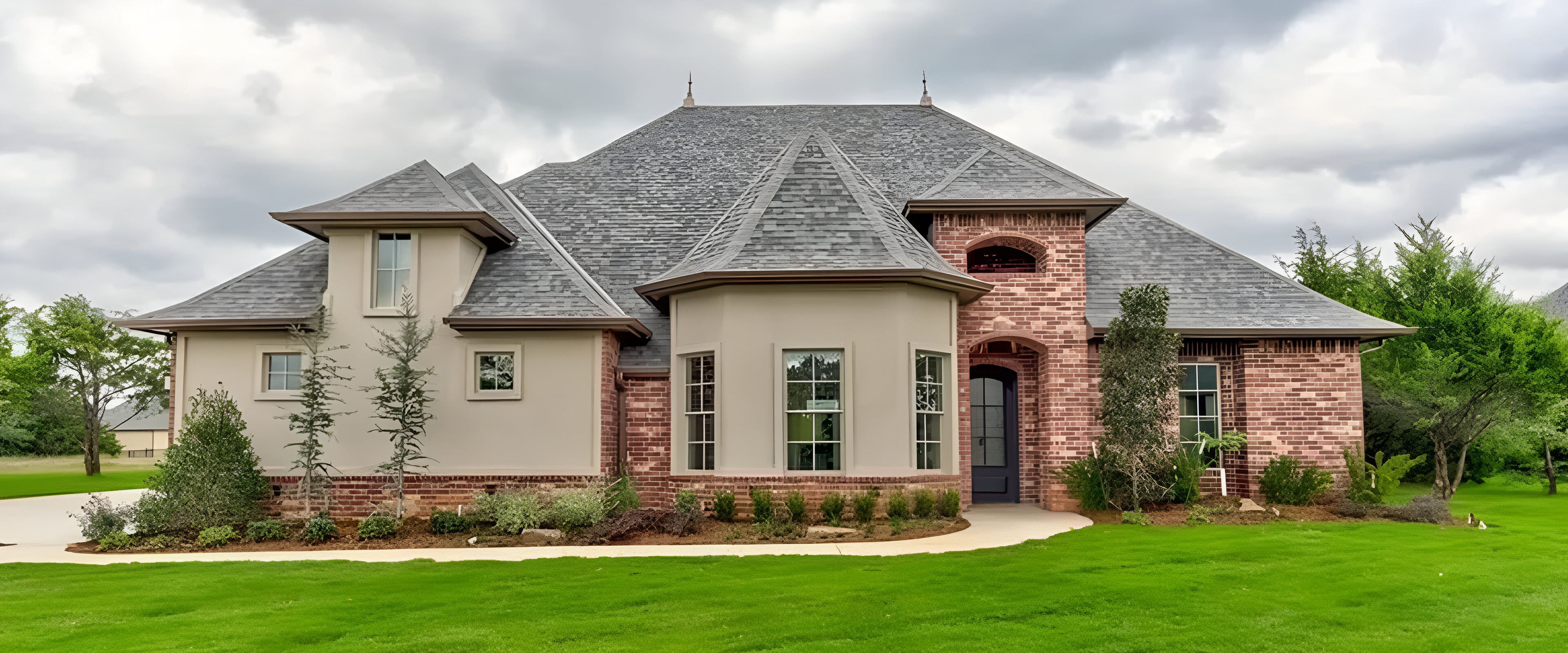 Brick and stucco house, landscaped lawn.